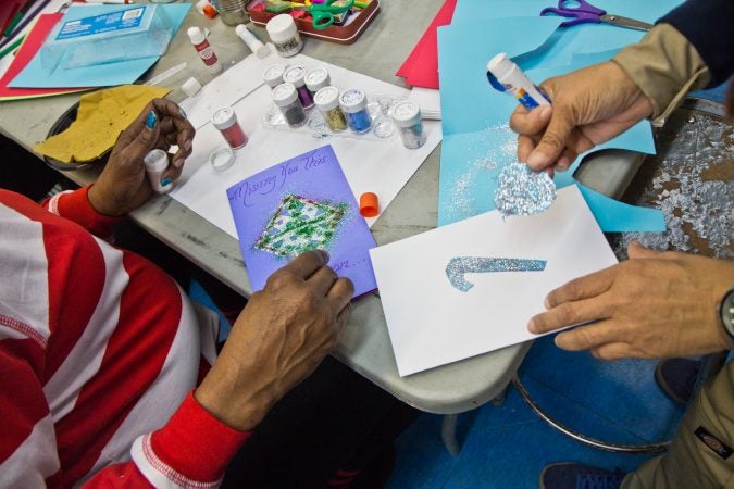 Community members make cards to send to incarcerated loved ones. (Kimberly Paynter/WHYY)