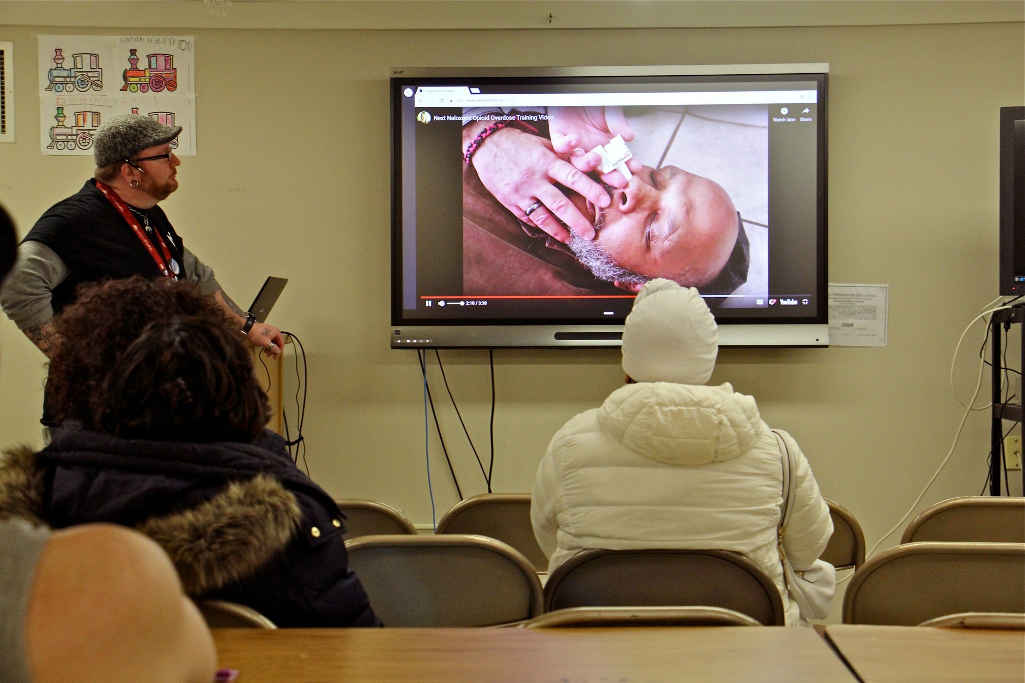 In the basement of Holmsburg Library, visitors watch a brief instructional video before receiving free naloxone, a drug administered nasally that reverses opioid overdoses. 