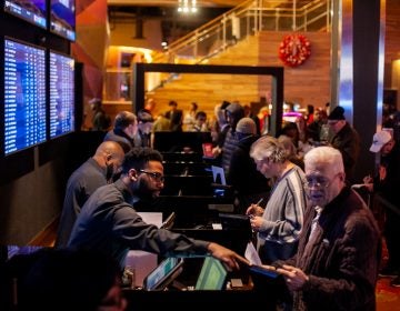 Prospective bettors place their wagers on sports events at the SugarHouse Casino Saturday morning. (Brad Larrison for WHYY)