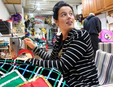 Amanda Kiesel sews Velcro onto sequined suspenders at the Avalon String Band club house in South Philadelphia while costume coordinator Jimmy Tatar uses a glue gun to add feathers to a hat.