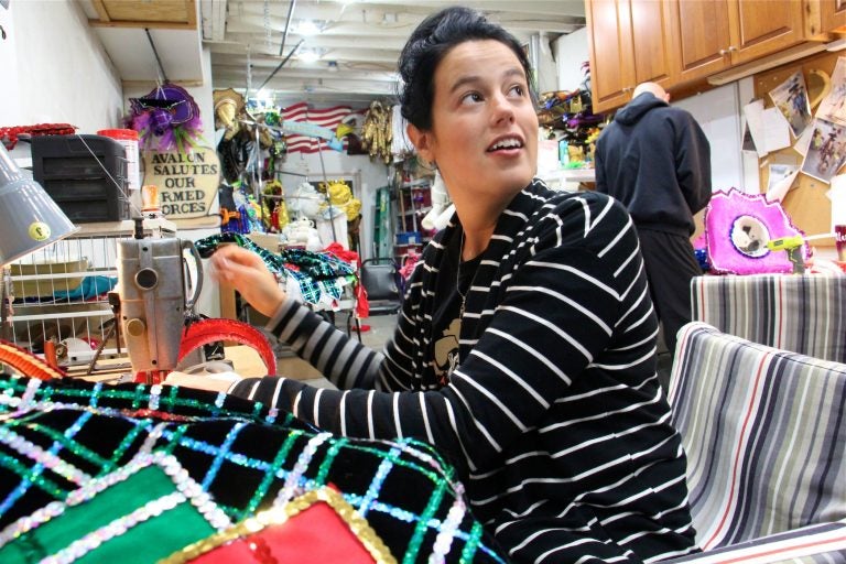 Amanda Kiesel sews Velcro onto sequined suspenders at the Avalon String Band club house in South Philadelphia while costume coordinator Jimmy Tatar uses a glue gun to add feathers to a hat.