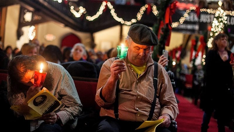 Bill Shriver (right) and Neil Davis, who is currently homeless, listen to the reading of 270 names of homeless or formerly homeless people who died in Philadelphia over the past year. (Brad Larrison for WHYY)