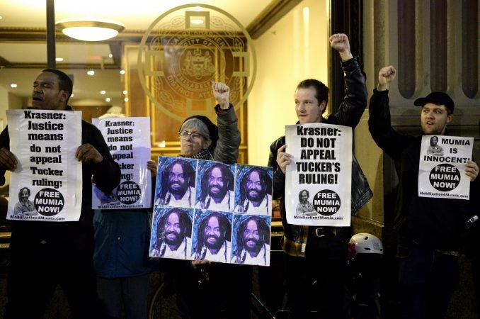 Activists raise their fists during a rally outside the Philadelphia district attorney's office Friday. (Bastiaan Slabbers for WHYY)