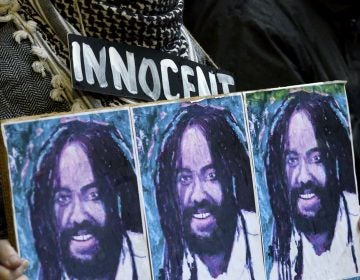 A group of two dozen activists briefly block traffic during a rally outside the Philadelphia District Attorney’s office in December, 2018. The group called on DA Larry Krasner to not challenge a Common Pleas court ruling that allows Mumia Abu-Jamal to file an appeal. (Bastiaan Slabbers for WHYY)