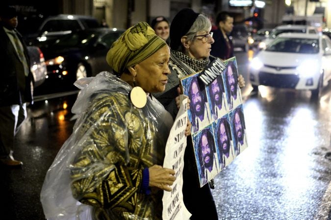 A group of activists briefly blocks traffic during a rally outside the Philadelphia district attorney’s office on Friday. (Bastiaan Slabbers for WHYY)