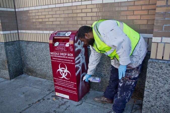 A clip worker removes graffiti around Kensington. (Kimberly Paynter/WHYY)