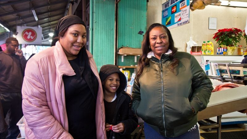 Tracey Prioleau (right) and her family shop for Christmas fish at Marcos in the Italian Market. (Kimberly Paynter/WHYY)