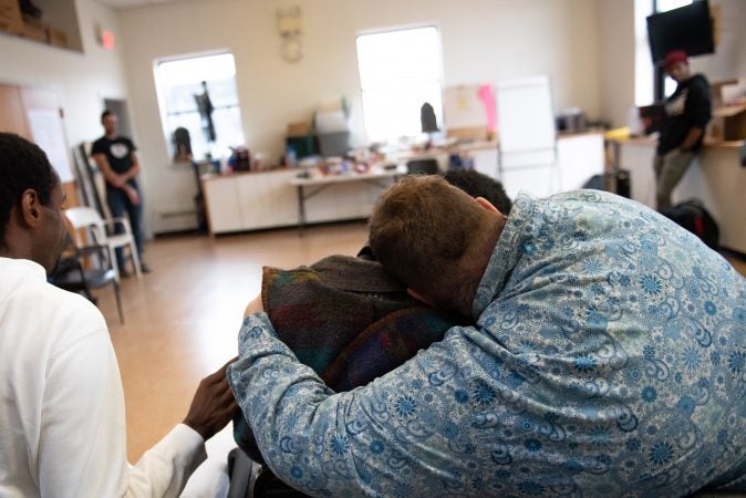 Curtis Walker embraces Dwight Dunston following an exercise where Dunston shouted what change he wanted to see during an exercise at a masculinity workshop held at Lutheran Settlement House on Sunday, October 28, 2018. (Kriston Jae Bethel for WHYY)