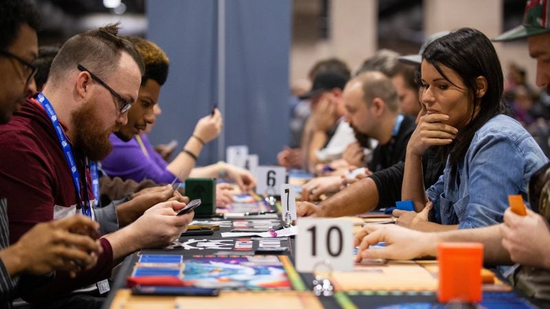 Jon Phillips and Jessica Rodriguez play the card game Lightseekers at PAX Unplugged on Friday, November 30, 2018. (Kriston Jae Bethel for WHYY)