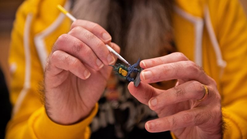 Ben Martin delicately paints a figure as part of a Miniatures Painting 101 workshop at PAX Unplugged. (Kriston Jae Bethel for WHYY)