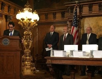 Members of the commission that studied the pension, standing behind binders full of documents. (Katie Meyer/WITF)