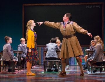 Laura Giknis as a first-grade teacher, Ian Merrill Peakes as Miss Trunchbull, and Jemma Bleu Greenbaum (far right), one of two actresses who play Matilda on different nights in the Walnut Street Theatre production of the musical 