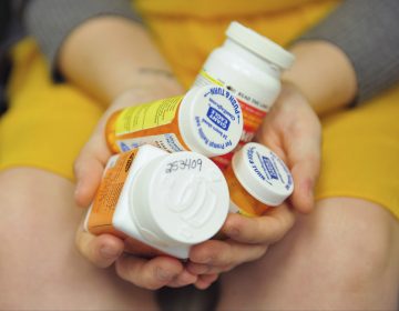 Heidi Wyandt, 27, holds a handful of her medication bottles at the Altoona Center for Clinical Research in Altoona, Pa., on Wednesday, March 29, 2017, where she is helping test an experimental non-opioid pain medication for chronic back pain related to a work related injury she received in 2014. (Chris Post/AP Photo)