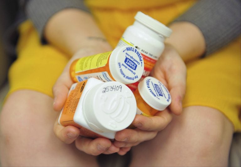 Heidi Wyandt, 27, holds a handful of her medication bottles at the Altoona Center for Clinical Research in Altoona, Pa., on Wednesday, March 29, 2017, where she is helping test an experimental non-opioid pain medication for chronic back pain related to a work related injury she received in 2014. (Chris Post/AP Photo)