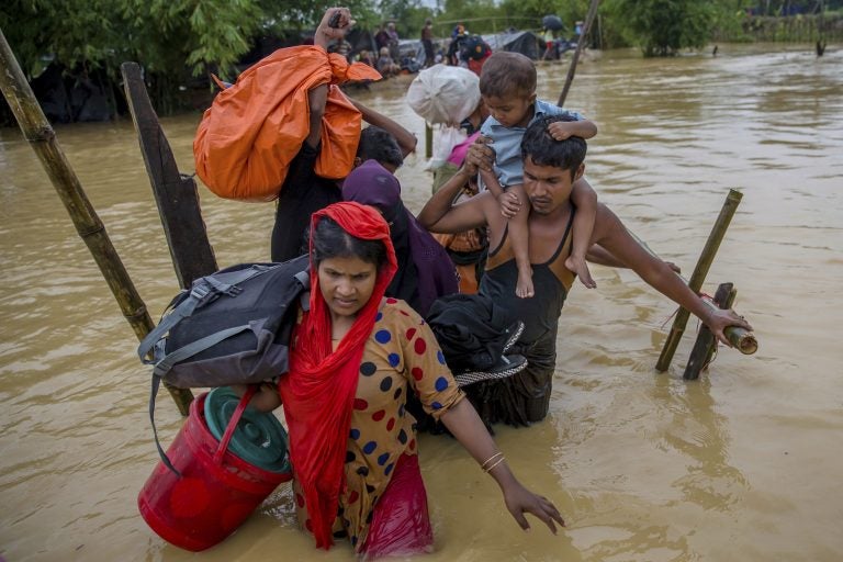 In this file photo, Rohingya Muslims, who crossed over from Myanmar into Bangladesh, use a makeshift footbridge as they move with their belongings after their camp was inundated with rainwater near Balukhali refugee camp, Bangladesh, Tuesday, Sept. 19, 2017.  (Dar Yasin/AP Photo)