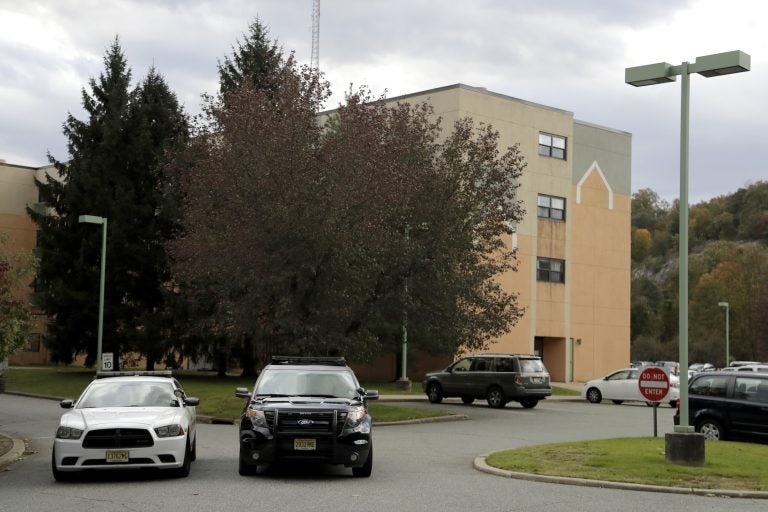 Police cruisers are seen parked near the entrance of the Wanaque Center For Nursing And Rehabilitation, where New Jersey state Health Department confirmed the 18 cases of adenovirus, Tuesday, Oct. 23, 2018, in Haskell, N.J.  (AP Photo/Julio Cortez)