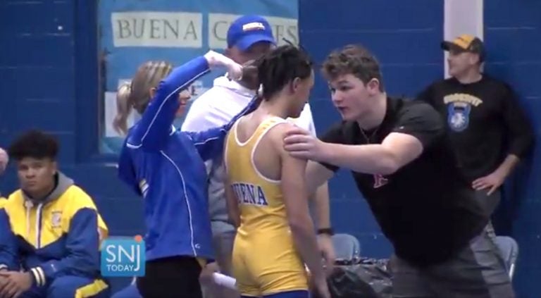 In this image taken from a Wednesday, Dec. 19, 2018 video provided by SNJTODAY.COM, Buena Regional High School wrestler Andrew Johnson gets his hair cut courtside minutes before his match in Buena, N.J., after a referee told Johnson he would forfeit his bout if he didn't have his dreadlocks cut off. Johnson went on to win the match after a SNJ Today reporter tweeted video if the incident, the state's Interscholastic Athletic Association says they are recommending the referee not be assigned to any event until the matter has been reviewed more thoroughly. (Michael Frankel/SNJTODAY.COM viavAP)
