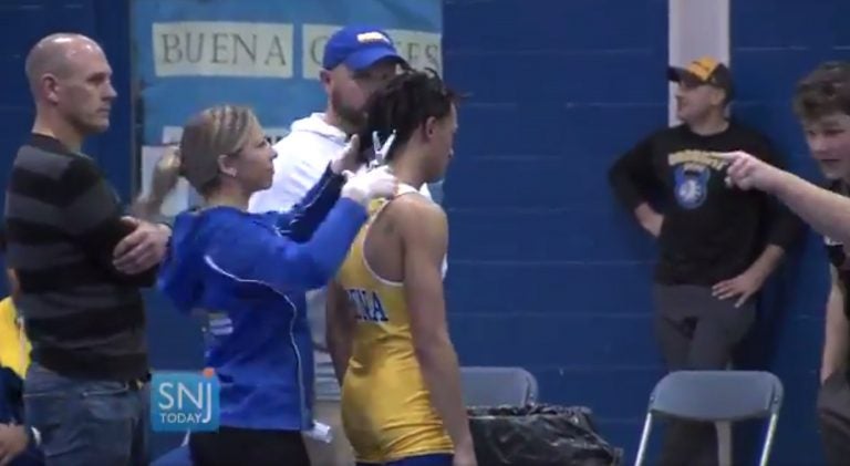 In this image taken from a Wednesday, Dec. 19, 2018 video provided by SNJTODAY.COM, Buena Regional High School wrestler Andrew Johnson gets his hair cut courtside minutes before his match in Buena, N.J. (Michael Frankel/SNJTODAY.COM via AP)