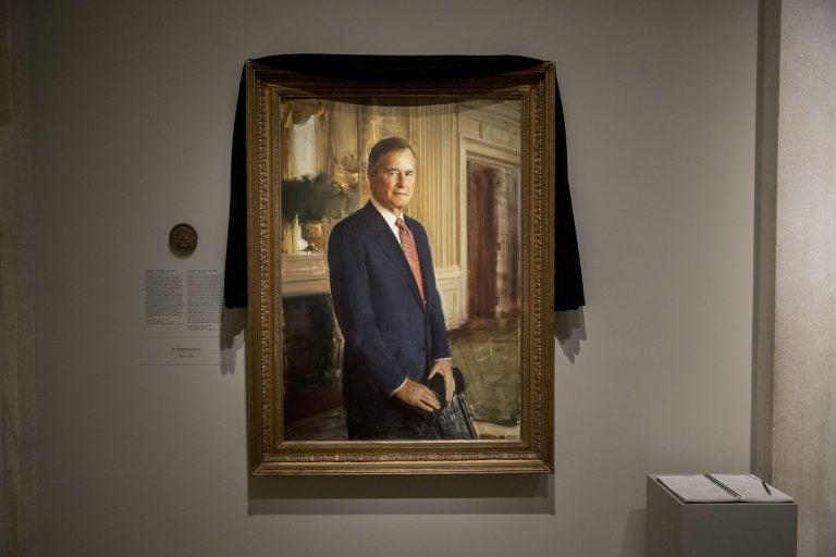 The official portrait of former President George H.W. Bush is draped in black cloth at the National Portrait Gallery in Washington, Monday, Dec. 3, 2018, to mark his passing. Bush will lay in state at the Capitol building this week before being buried in Texas. (AP Photo/Andrew Harnik)