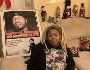 Sheila Reid, whose son, Jerame, was shot and killed by police in 2014, has urged Gov. Phil Murphy to sign a bill requiring New Jersey to investigate all police-involved deaths. She’s sitting in front of a poster made to remember him, that spells his name the way it’s pronounced. (Ang Santos for WHYY)