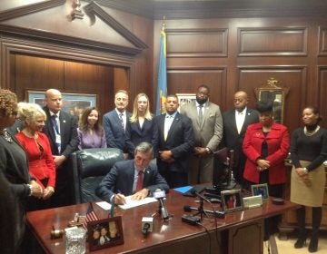 Delaware Gov. John Carney signs an executive order Tuesday aimed at reducing recidivism. (Zoe Read/WHYY)