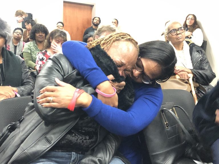 Sharon Osburn (left) fights back tears after telling prison officials about her son's sudden transfer to a Pennsylvania prison. Osburn is being comforted by state Rep. Sherry Dorsey Walker of Wilmington. (Cris Barrish/WHYY)