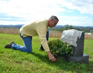 Jeff Sterner adjusts a flower display on his son Joshua’s grave. Josh was 19 in 2012 when he died by suicide. (Brett Sholtis / Transforming Health)