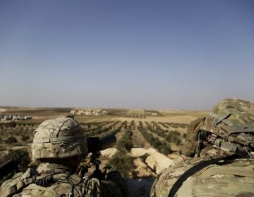 American troops look toward the border with Turkey from a small outpost near the town of Manbij, northern Syria, in February. (Susannah George/AP)