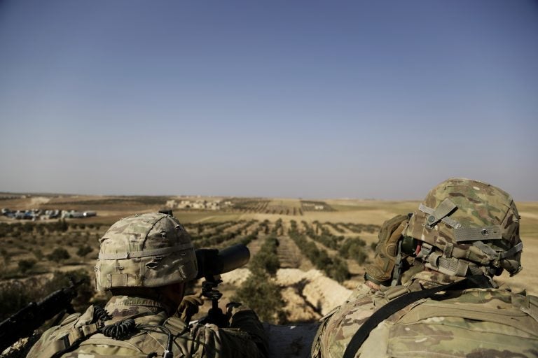 American troops look toward the border with Turkey from a small outpost near the town of Manbij, northern Syria, in February. (Susannah George/AP)