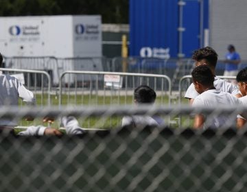 Migrant children run around a track outside at the Homestead Temporary Shelter for Unaccompanied Children in Homestead, Fla. Shelters that house these children are reaching capacity and the federal government is now working to speed releases to sponsors. (Brynn Anderson/AP)