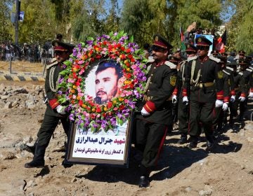 Guards of honor carry a photo of Brig. Gen. Abdul Raziq, Kandahar police chief, at his burial ceremony in Kandahar in October. (AP)