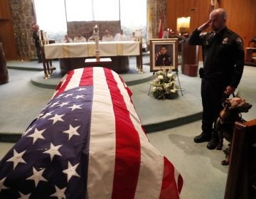 As of Dec. 27, this year 144 federal, state and local law enforcement officers have died in the line of duty — a rise from the 129 officers killed in 2017. Here, wounded Dekalb County Police K9 Indi stands by his handler's side during a funeral service for Edgar Flores on Dec. 18 in Georgia. (John Bazemore/AP)