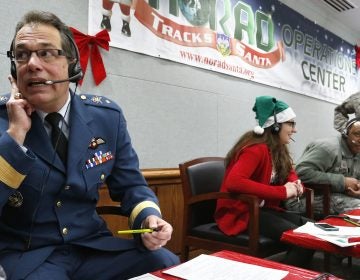 Every year, NORAD staff and volunteers field calls from children inquiring about Santa. Canadian Brig. Gen Guy Hamel joined in the tradition in 2014. (Brennan Linsley/AP)