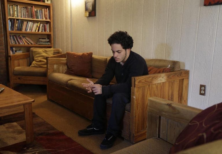 In this Thursday, April 24, 2014 photo, Jose Osario, 20, a resident of the transition cottage, sits in the living room of another cottage at the Children's Village campus in Dobbs Ferry, N.Y. (AP Photo/Seth Wenig)