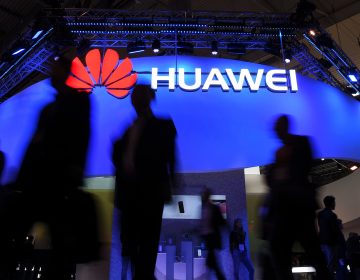 Visitors pass a Huawei marquee in Barcelona during the Mobile World Congress last year. The daughter of the Chinese telecommunications giant's founder was arrested Saturday in Canada on U.S. request, in a move that threatens to inflame U.S.-China trade tensions. (Lluis Gene/AFP/Getty Images)