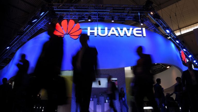 Visitors pass a Huawei marquee in Barcelona during the Mobile World Congress last year. The daughter of the Chinese telecommunications giant's founder was arrested Saturday in Canada on U.S. request, in a move that threatens to inflame U.S.-China trade tensions. (Lluis Gene/AFP/Getty Images)