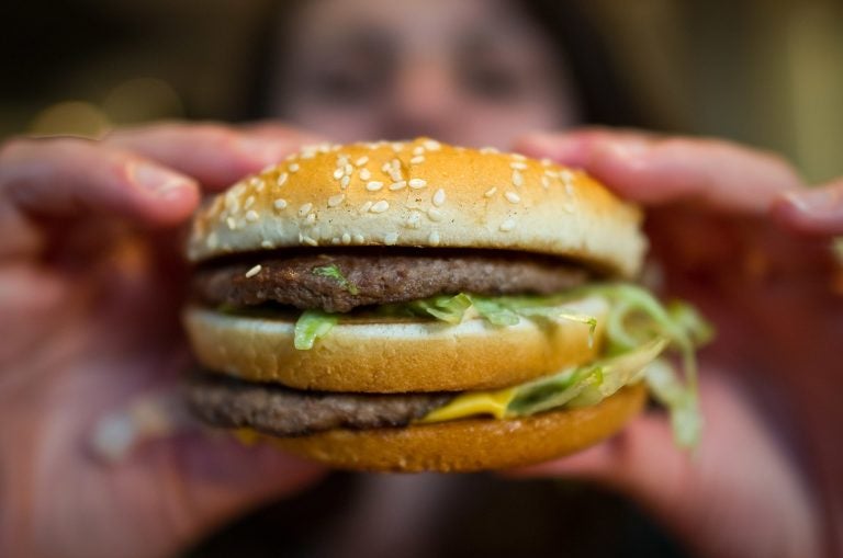 A customer holds a McDonald's Big Mac. The fast-food giant, one of the world's biggest beef buyers, has announced plans to use its might to cut back on antibiotics in its global beef supply. Environmentalists are applauding the commitment. (Christoph Schmidt/Picture Alliance via Getty Images)