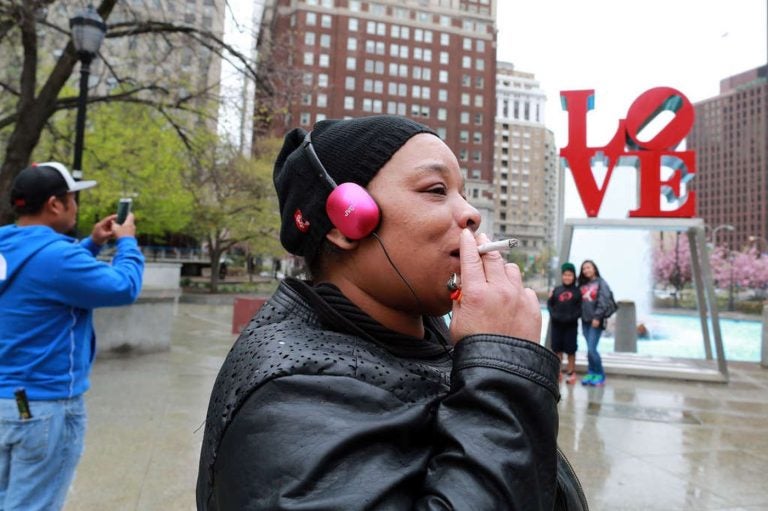 A woman smokes a cigarette at JFK Plaza (David Swanson/Philadelphia Inquirer) 