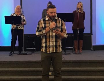 Youth pastor Kyle Smith of First Assembly of God Paradise reads from the Bible on his phone because his copy of the book burned in the Camp Fire. His congregation is one of several now worshiping with congregations in Chico.
(Polly Stryker/KQED)