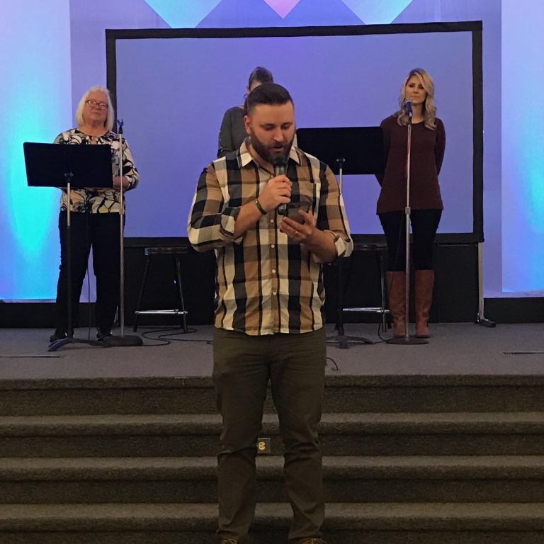 Youth pastor Kyle Smith of First Assembly of God Paradise reads from the Bible on his phone because his copy of the book burned in the Camp Fire. His congregation is one of several now worshiping with congregations in Chico.
(Polly Stryker/KQED)