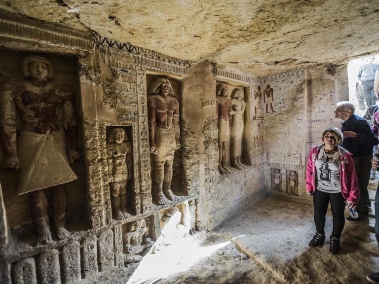 Visitors enter a newly-discovered Egyptian tomb at the Saqqara necropolis on Saturday. (Khaled Desouki/AFP/Getty Images)