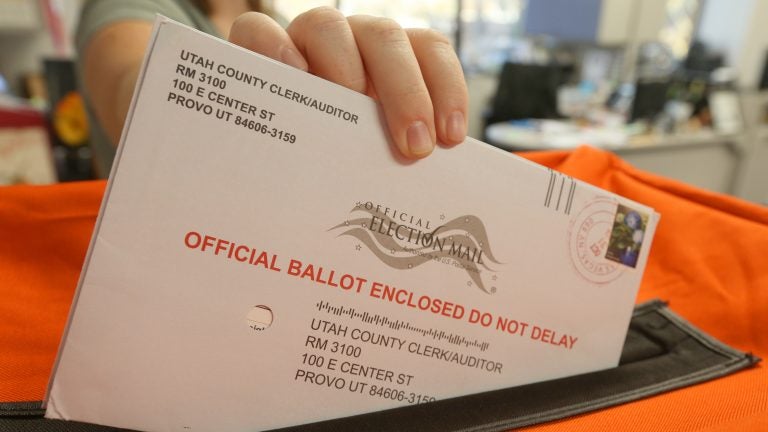 An employee at the Utah County Election office puts mail in ballots into a container to register the vote in the midterm elections on November 6.
(George Frey/Getty Images)