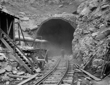 In the photo above, dust circles a worker during the construction of the Hawks Nest Tunnel in 1930. Workers on the project were exposed to toxic levels of silica dust; hundreds ultimately died.
(Courtesy of Elkem Metals Collection, West Virginia State Archives)