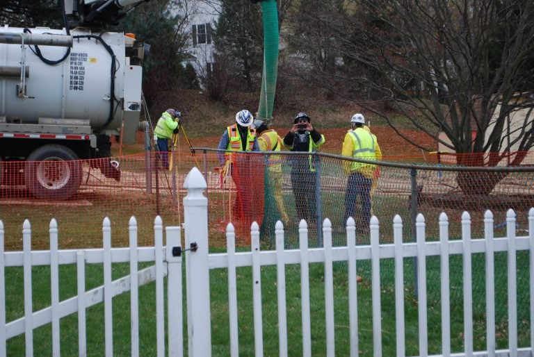 In this May 2018 photo, workers and contractors for Sunoco Pipeline investigate sink holes behind homes at Lisa Drive, West Whiteland Township, Chester County where the company has been drilling for construction of the Mariner East 2 and 2X pipelines. The company offered to relocate residents of the five homes whose yards are crossed by the pipeline right of way. (Jon Hurdle/StateImpact Pennsylvania)