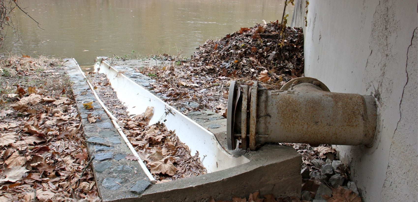 A discharge pipe at the W. Compton Wills Pumping Station empties into the Brandywine Creek in Wilmington. (Emma Lee/WHYY)