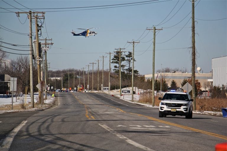 A state police helicopter lands near a UPS facility in Logan Township where two women were held hostage by a gunman. (Emma Lee/WHYY)