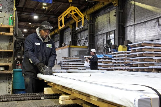 Workers prepare steel for shipment at Camden Yards Steel Company. (Emma Lee/WHYY)
