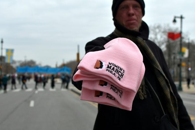 An unidentified sales person asks $10 for these hats commemorating the Women's March in Philadelphia, Pa., on January 19, 2019. (Bastiaan Slabbers for WHYY)