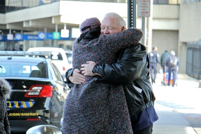 Alora Miller hugs Joe Shuker, president of the local American Federation of Government Employees, after she dropped off a load of donated supplies for TSA workers at Philadelphia International Airport. (Emma Lee/WHYY)