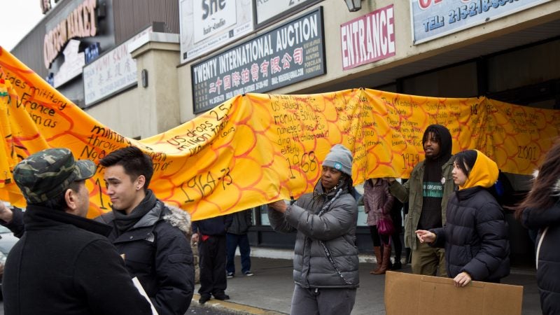 Members and supporters of Philadelphia’s Southeastern Asian community carry a history dragon to protest deportations at a shopping center on West Oregon Avenue on Sunday, Jan. 27, 2019. (Kimberly Paynter/WHYY)